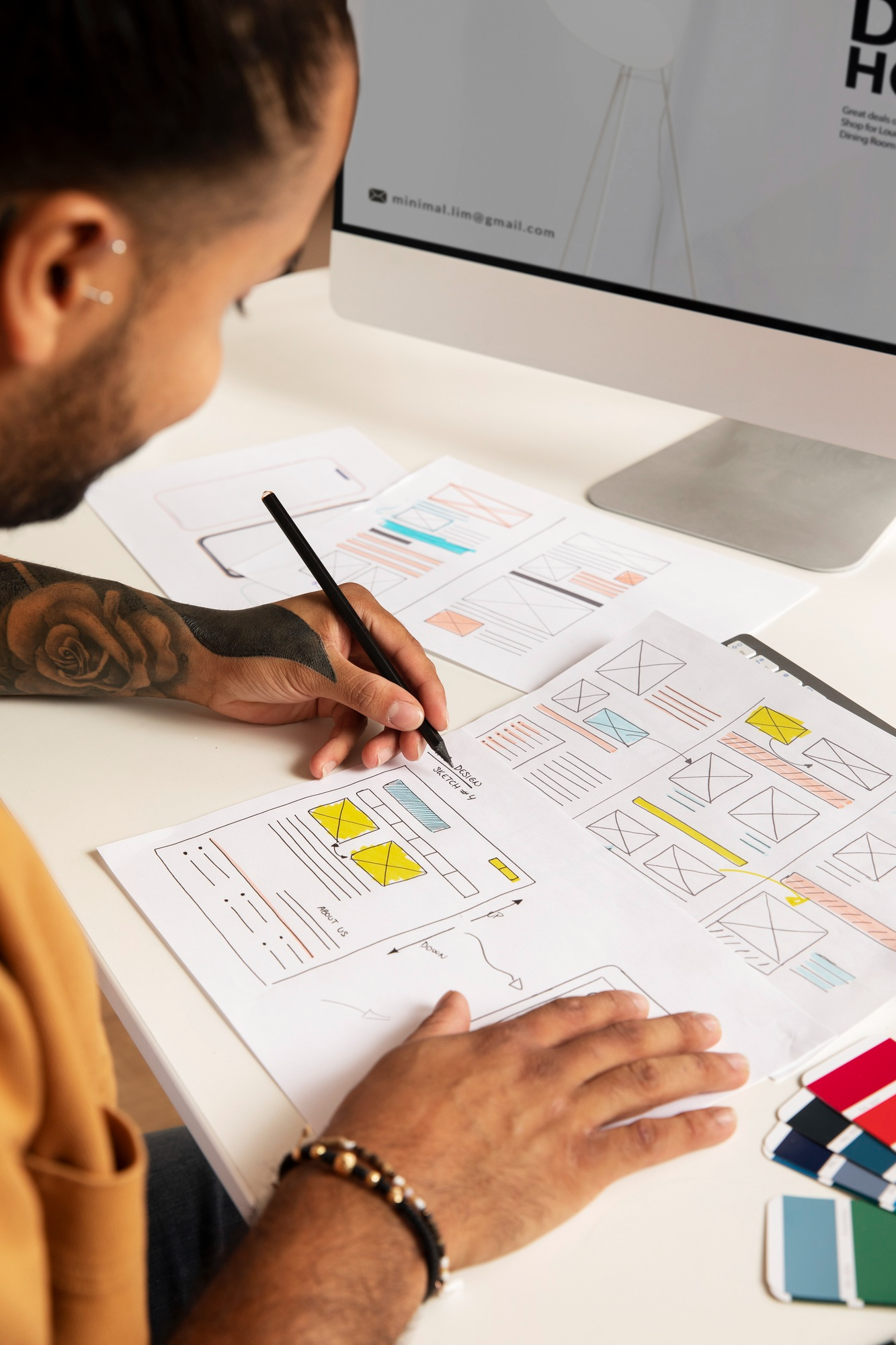 Illustration of a person sketching a website structure and layout on paper, representing the planning phase of web design.